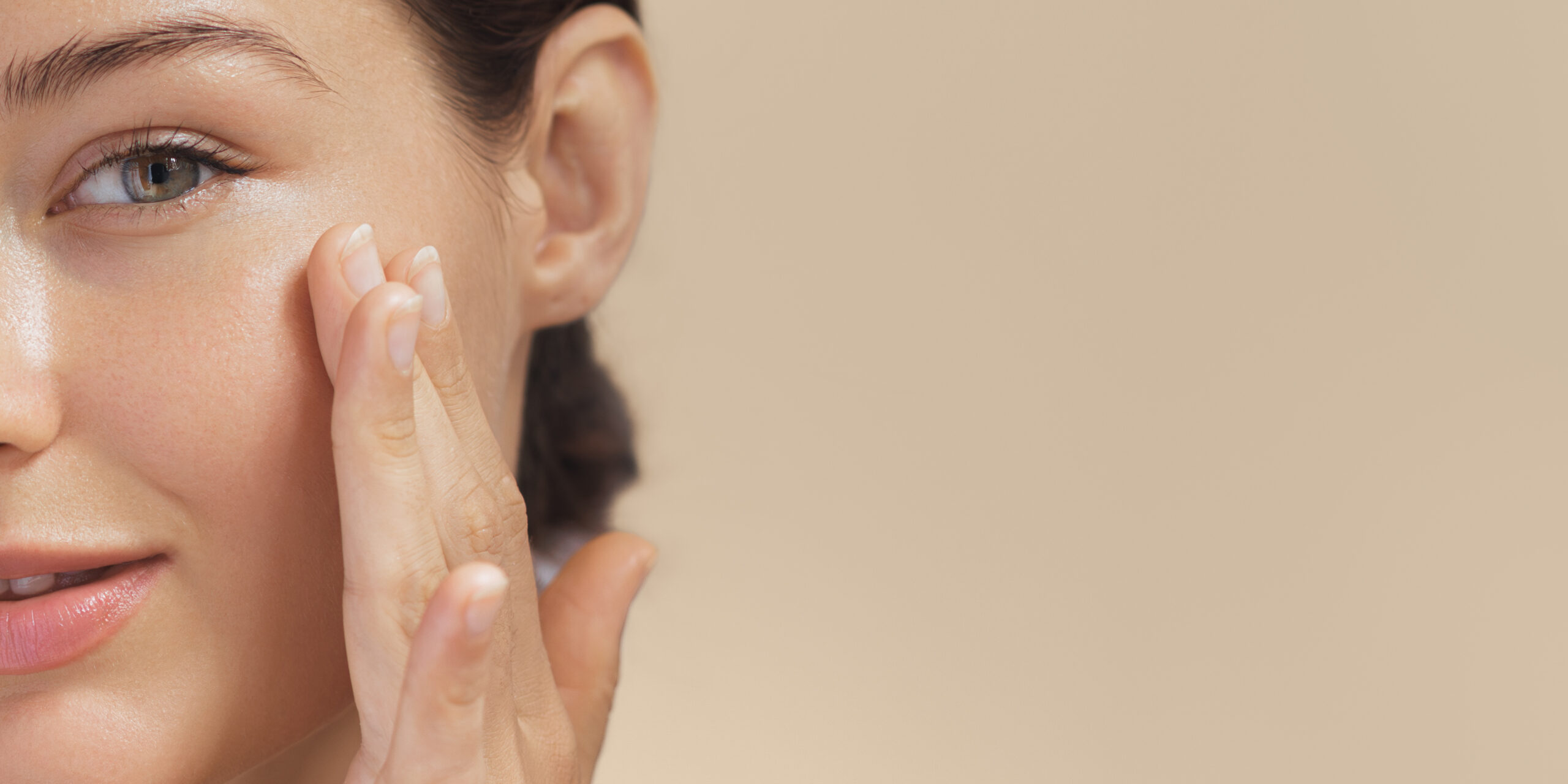 A woman touching her left face showing the effect of Halo Treatment at Desert Eyesthetics in Gilbert, AZ.